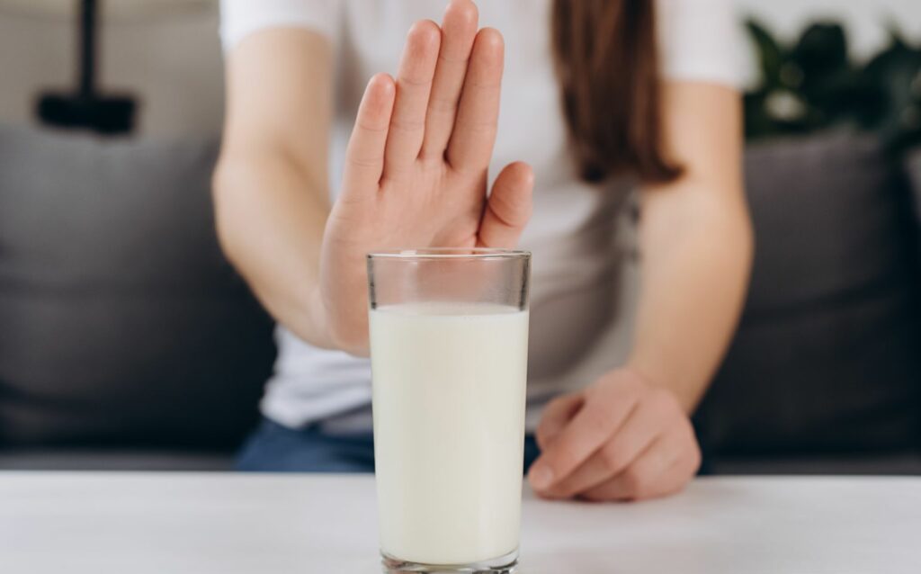 牛乳を避ける女性の手